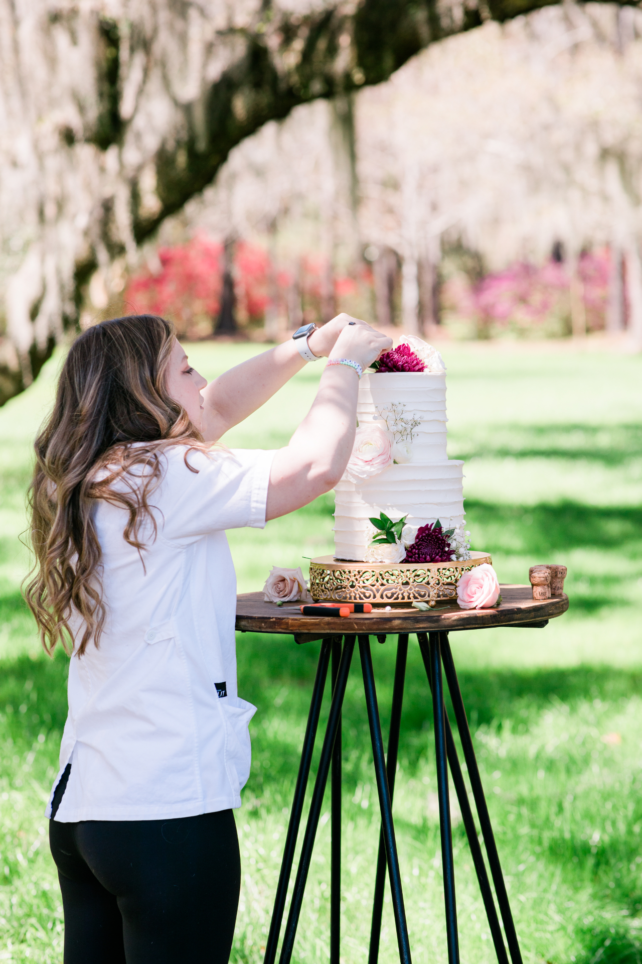 Alexandra Kowaleski finishing a custom cake outdoors